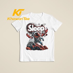 May include: A white short-sleeve t-shirt featuring a graphic of an astronaut reaching out from a rocky surface. The design includes the text "Sleep 2026 Tour" with a moon, planets, and stars in the background. The logo "KhawanTee" is printed in yellow.