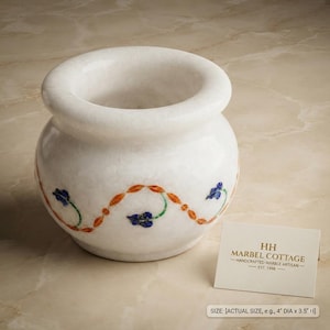 Op de afbeelding: Een witte marmeren kom met een ronde vorm en een brede opening. De buitenkant is voorzien van een decoratief inlegpatroon van oranje ranken en blauwe bloemen. Een kaartje toont de tekst HH MARBEL COTTAGE en de afmetingen 10,16 cm bij 8,89 cm.