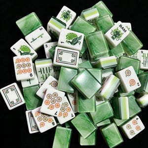 a collection of green and white tiles or blocks, possibly used for a game or decoration, scattered on a black background.