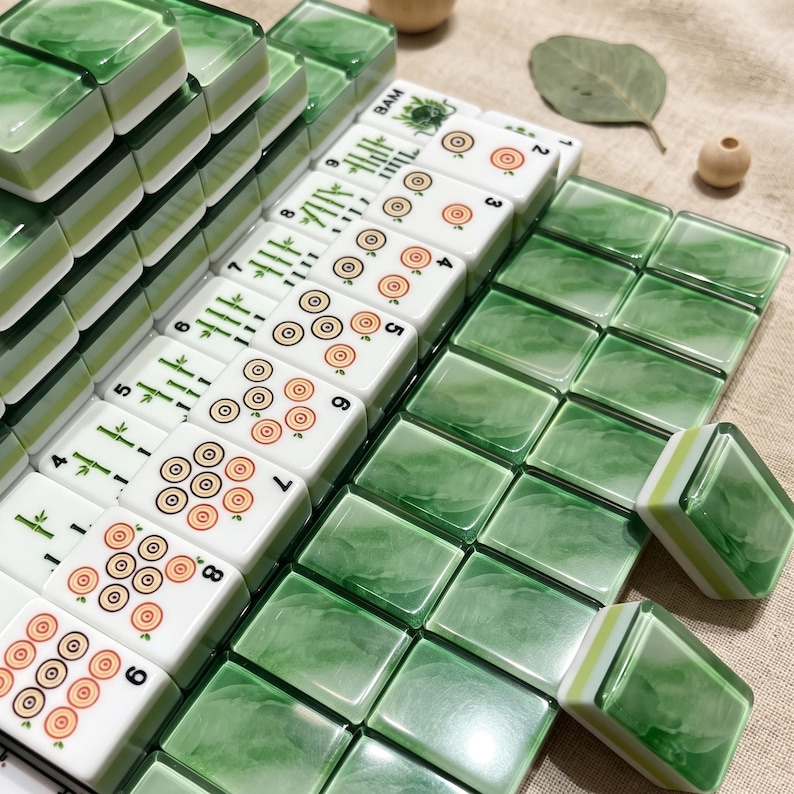 a collection of green and white dominoes arranged on a surface, with some dominoes partially detached from the stack.