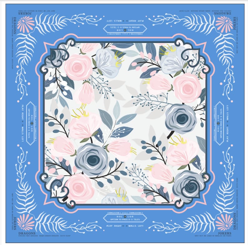 a square pattern with a floral design, including pink and blue flowers, leaves, and branches. The pattern is framed by a blue border with a decorative border.