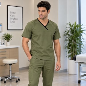 May include: An olive green scrub set consisting of a short-sleeved V-neck top with black trim and matching drawstring pants. The top features a horizontal seam across the chest and two lower pockets, while the pants include side cargo pockets.