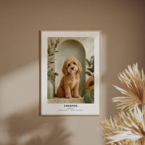 May include: A framed wall art print featuring a portrait of a golden-brown Cavapoo dog sitting in front of an arched alcove with green plants. The text below the dog reads CAVAPOO, APRICOT, and AFFECTIONATE - CLEVER - SOCIABLE in black font.