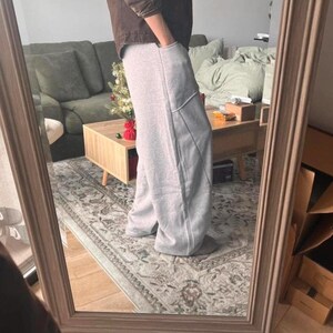 Peut inclure: Pantalon de jogging gris clair &agrave; coupe large, taille haute, avec des coutures verticales marqu&eacute;es sur le devant de chaque jambe. Ce pantalon est dot&eacute; de poches lat&eacute;rales profondes et est confectionn&eacute; dans un tissu chin&eacute; doux et confortable.