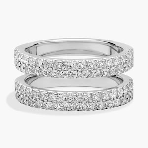 Könnte beinhalten: Ein Doppelring aus poliertem, silberfarbenem Metall mit zwei parallelen Reihen kleiner, klarer, rund geschliffener Steine, die entlang der gesamten Außenfläche jedes Rings eingelassen sind und einen durchgehenden Glanzeffekt erzeugen.