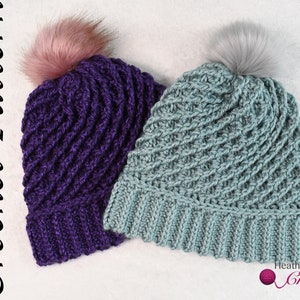 May include: Two crocheted hats with faux fur pom poms. One hat is purple and the other is light blue.