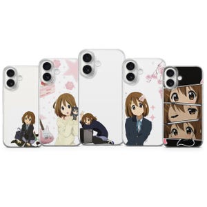 Pode incluir: Cinco capas para smartphone com ilustrações de personagens em estilo anime. Os designs incluem uma rapariga com uniforme escolar, uma rapariga com camisola creme e guitarra, uma rapariga apoiada num amplificador, flores de cerejeira e um plano.