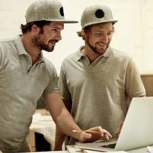 Puede incluir: Dos polos de color gris claro y dos gorras de béisbol de color gris claro con un logotipo circular negro en la parte delantera. Las gorras presentan una visera plana y una corona estructurada. Los polos tienen cuello clásico, tapeta con botones y mangas cortas.