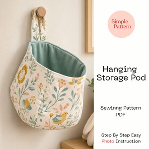 May include: A hanging storage pod featuring a cream-colored fabric with a floral and bird pattern in shades of yellow, pink, and green. The interior is lined with solid sage green fabric. Text reads: Simple Pattern, Hanging Storage Pod, Sewing Pattern PDF, Step By Step Easy Photo Instruction.
