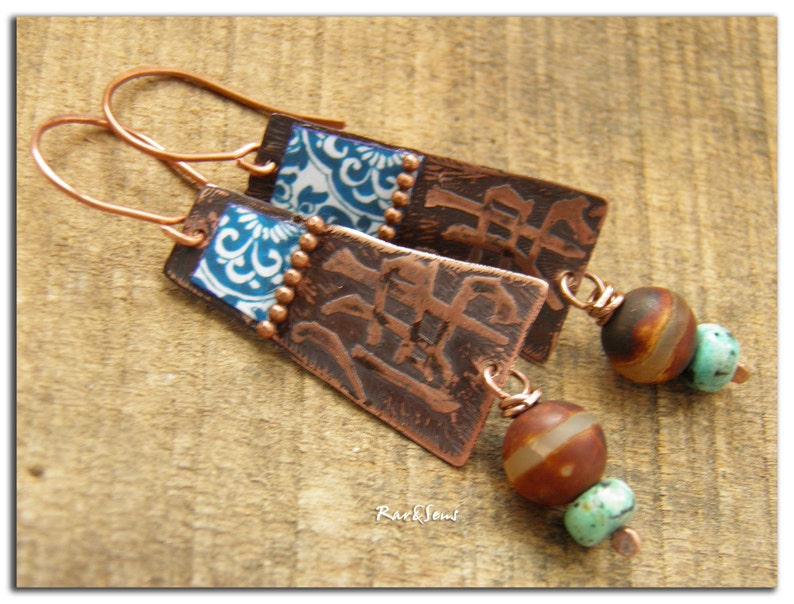 May include: Copper earrings with blue and white patterned squares, brown and turquoise beads, and the Chinese character for "peace" embossed on the copper.