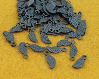 May include: A pile of black metal leaf charms with a loop at the top. The charms are about 1 inch long and have a detailed leaf design.