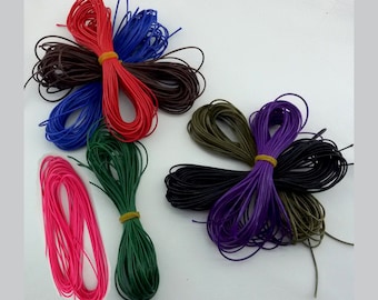 May include: Assortment of colorful cords in various hues, including red, blue, brown, green, pink, black, and purple. Each bundle is secured with a yellow rubber band. These cords are suitable for crafting and jewelry making.