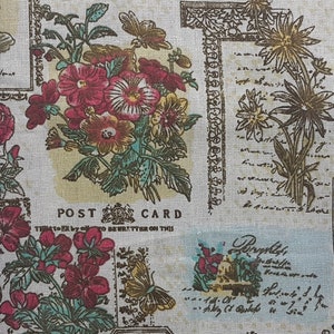 May include: A white fabric with a floral pattern featuring red, pink, and yellow flowers. The fabric also has a vintage postcard design with the words "Post Card" and "This space to be written on this side".