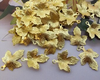 May include: A large quantity of gold-colored metal leaf charms with a detailed leaf design. Each charm has a loop at the top for attaching to jewelry or other crafts.