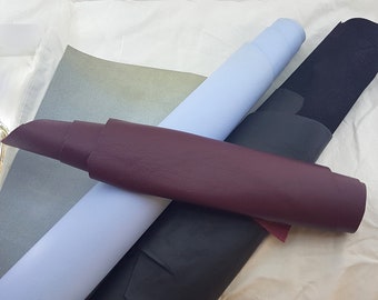 May include: Three rolls of fabric in different colors: light blue, dark gray, and burgundy. The fabric is smooth and has a slight sheen.