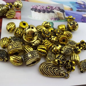 Perline acriliche color oro antico, mix di perline acriliche color oro, perline acriliche dal design etnico, perline acriliche color oro miste, assortimento di perline color oro, perline color oro miste