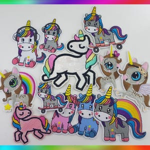 May include: A selection of embroidered unicorn patches in various colours. The unicorns feature rainbow manes and horns, with some wearing headphones or riding skateboards. Patches include pink, blue, and grey unicorns.