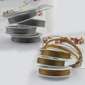 Può includere: Due bobine di filo per composizioni floreali. Una bobina è argentata e l'altra è dorata.