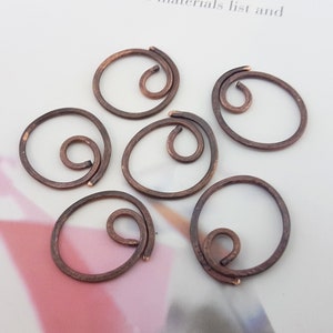 Könnte beinhalten: Sechs kupferfarbene Draht-Sprünge mit Spiraldesign. Die Ringe haben einen Durchmesser von etwa 2,5 cm.