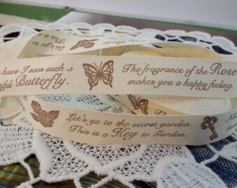 May include: A roll of white cotton ribbon with brown printed text and images. The text reads "Never have I seen such a beautiful Butterfly." "The fragrance of the Rose makes you a happy feeling." "Let's go to the secret garden. This is a Key to Garden."