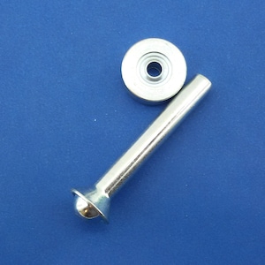 May include: A silver metal tool for setting eyelets. The tool has a long handle and a round head with a hole in the center. The tool is used to press eyelets into fabric or leather.