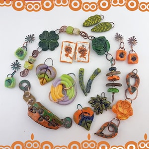 May include: A selection of handcrafted jewellery items, including earrings, pendants, and a bracelet. The jewellery features various shapes like leaves, flowers, and geometric designs, with a mix of colours such as green, orange, and purple. The pieces are arranged on a white surface.