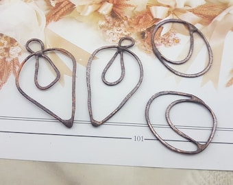 May include: Four rustic brown metal wire shapes, including a heart, two teardrop shapes, and a circle with a smaller circle inside. The shapes are on a white background.