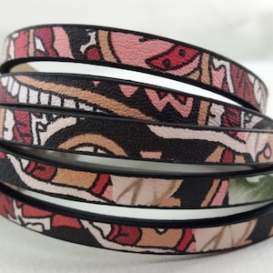 Puede incluir: Correas de cuero con estampado multicolor y bordes negros. Las correas están superpuestas y tienen una variedad de diseños geométricos y florales.