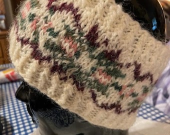 May include: White knitted headband with a burgundy, green, and pink floral pattern.