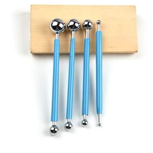 May include: Set of four blue-handled ball tools with silver metal tips of varying sizes. The tools are arranged in order of size, with the largest ball tool on the left and the smallest ball tool on the right.