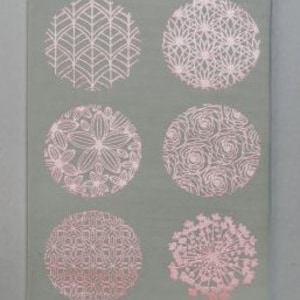 May include: Six circular designs with intricate patterns in pink on a gray background. The designs include geometric shapes, floral motifs, and abstract patterns.