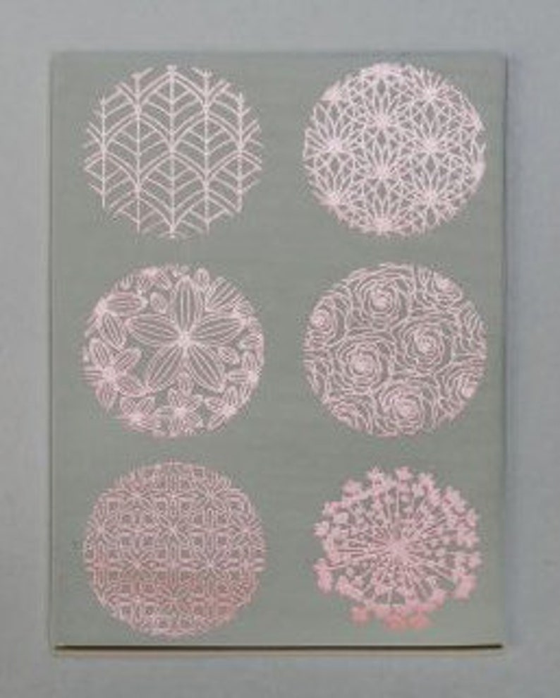 May include: Six circular designs with intricate patterns in pink on a gray background. The designs include geometric shapes, floral motifs, and abstract patterns.