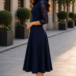 Puede incluir: Un vestido midi azul marino con mangas tres cuartos con intrincados detalles de encaje, cuello alto y falda acampanada. La prenda se combina con zapatos de tac&oacute;n alto negros de punta fina, creando una apariencia cohesiva y estructurada.