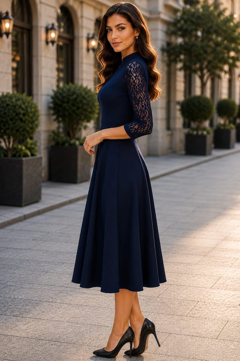 Puede incluir: Un vestido midi azul marino con mangas tres cuartos con intrincados detalles de encaje, cuello alto y falda acampanada. La prenda se combina con zapatos de tac&oacute;n alto negros de punta fina, creando una apariencia cohesiva y estructurada.