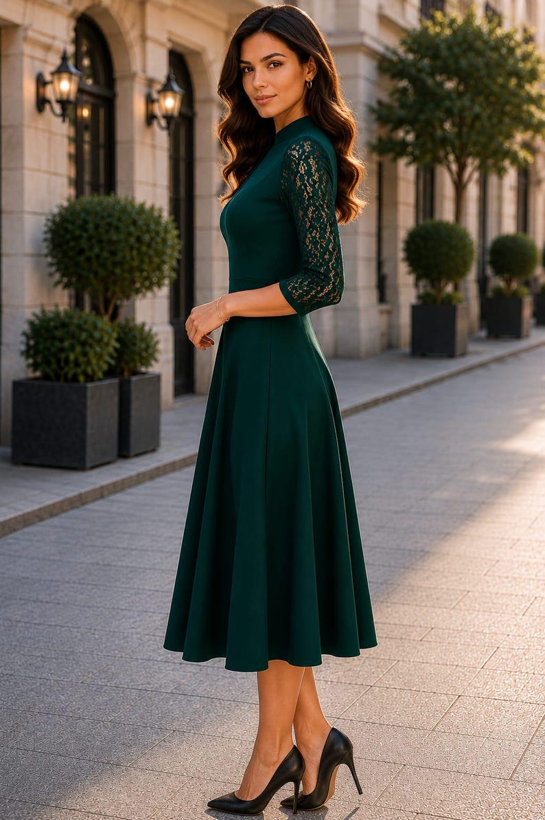 Puede incluir: Un vestido midi de color verde oscuro con mangas de encaje de tres cuartos, cuello alto y falda acampanada. La prenda se combina con zapatos de tac&oacute;n alto negros, creando un conjunto coherente con un cuerpo liso y detalles de encaje floral.