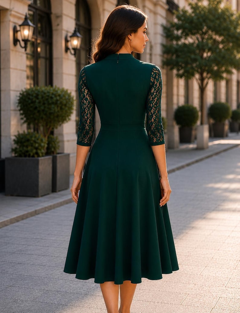 Puede incluir: Un vestido midi de color verde oscuro con cuello alto, mangas tres cuartos con detalles de encaje intrincados y una falda acampanada. La parte posterior del vestido incluye una cremallera oculta, lo que proporciona una silueta limpia y estructurada.