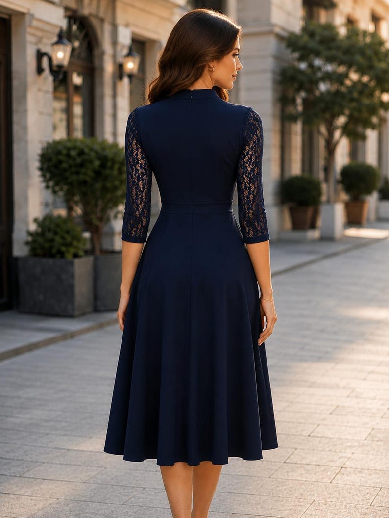 Puede incluir: Un vestido midi azul marino con mangas de encaje de tres cuartos, cuello alto y un corpi&ntilde;o ajustado que se transforma en una falda acampanada. La prenda es de color azul marino s&oacute;lido con detalles de encaje floral en las mangas.