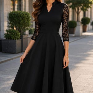 Puede incluir: Un vestido midi negro con escote en V y mangas tres cuartos de encaje negro intrincado. El corpi&ntilde;o es ajustado y se transforma en una falda acampanada en forma de A que cae por debajo de las rodillas, creando una silueta estructurada.