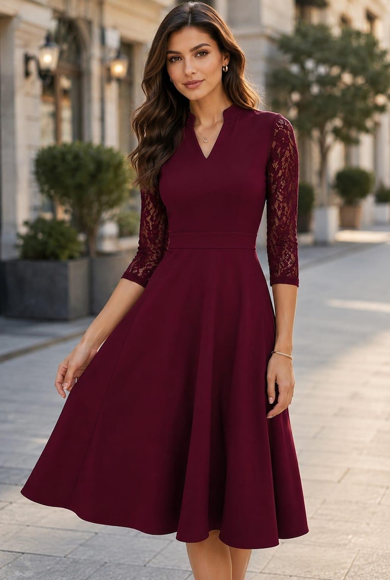 Puede incluir: Un vestido midi color burdeos con escote en V, cuerpo entallado y mangas tres cuartos de encaje floral intrincado. La falda es acampanada y llega por debajo de las rodillas, creando una silueta estructurada con un acabado de color s&oacute;lido.
