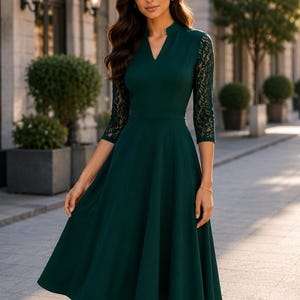 May include: A dark green midi dress featuring a V-neckline, a fitted bodice, and three-quarter length sleeves with intricate lace detailing. The skirt has a flared silhouette that falls below the knees, creating a structured and elegant appearance.