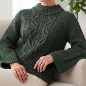 Könnte beinhalten: Ein dunkelwaldgrüner Langarmpullover mit Stehkragen, gerippten Bündchen und einem markanten vertikalen Zopfstrickmuster auf der Vorderseite sowie zusätzlichen Zopfstrickdetails entlang der Ärmel.