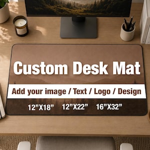 Può includere: Un tappetino da scrivania rettangolare con una stampa paesaggistica marrone di montagne e pini. Il tappetino mostra il testo bianco Custom Desk Mat, Add your image / Text / Logo / Design, e le dimensioni 12"X18", 12"X22", e 16"X32".