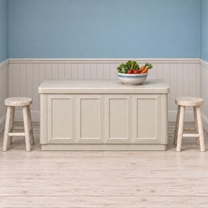 Peut inclure: Un îlot de cuisine rectangulaire avec une finition beige clair et quatre panneaux encastrés sur le devant, flanqué de deux tabourets en bois ronds assortis. Un bol en céramique blanche rempli de laitue verte, tomates et carottes est posé dessus.