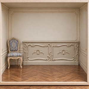 May include: A light gray wooden console table featuring intricate carved floral and shell motifs, positioned against a paneled wall next to a single chair upholstered in blue fabric with a repeating light gray floral pattern.
