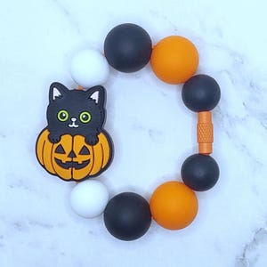 Schwarze Katze Halloweens im Kürbis-Cup-Charme