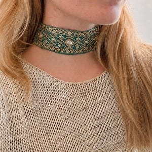 Könnte beinhalten: Ein breites Choker-Halsband mit einer tief-türkisfarbenen Stoffbasis, verziert mit aufwendigen goldfarbenen Metallstickereien, kleinen runden Pailletten und klaren facettierten Kristallakzenten in einem sich wiederholenden Gittermuster.