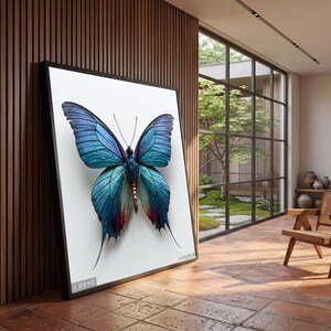 May include: A large rectangular framed wall art piece featuring a detailed illustration of a butterfly with iridescent blue and teal wings, dark veining, and reddish-purple accents at the lower wing tips, set against a plain white background.