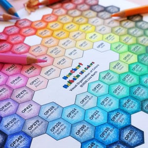Könnte beinhalten: Ein Hex Chart Holbein 150 Colors Organisationsblatt mit einem Wabenmuster aus farbigen Sechsecken mit Beschriftungen wie OP120 Peach und OP349 Ultra Blue, umgeben von mehreren Buntstiften auf einer hellrosa Oberfläche.