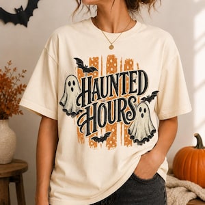 Peut inclure: Un t-shirt à manches courtes de couleur crème avec une impression graphique portant le texte "HAUNTED HOURS" en écriture noire. Le motif comprend deux fantômes blancs, trois chauves-souris noires et un fond orange à rayures et pois.