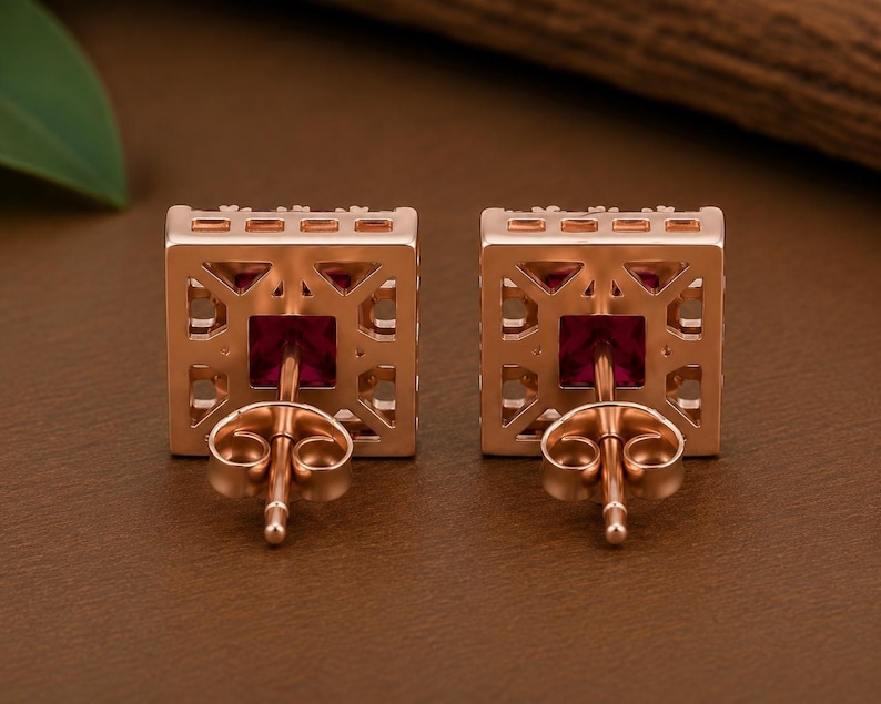 Peut inclure: Une paire de boucles d'oreilles carr&eacute;es dot&eacute;es d'une monture en m&eacute;tal dor&eacute; rose au design g&eacute;om&eacute;trique ajour&eacute;. Chaque boucle d'oreilles pr&eacute;sente une pierre pr&eacute;cieuse rouge fonc&eacute; de taille carr&eacute;e avec une tige et un fermoir papillon assortis.